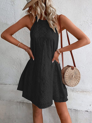 Black halter neck eyelet trapeze mini dress with a flared skirt.