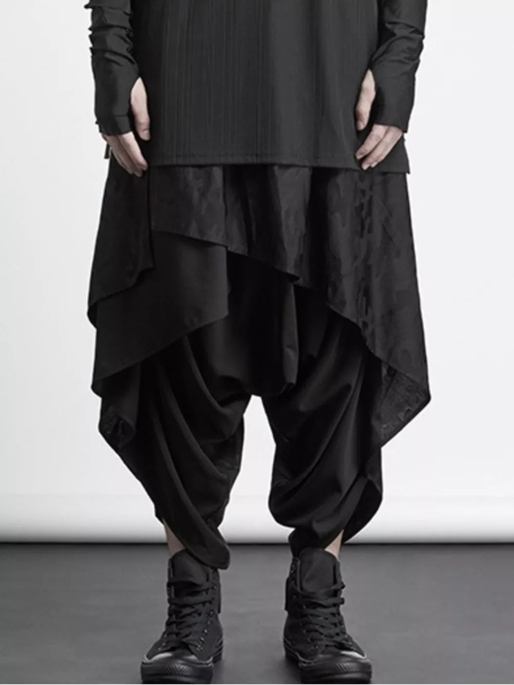 Black avant-garde harem sweatpants with asymmetrical layered detail and a dropped crotch.