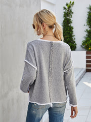Dark gray knit pullover sweater with white trim and frayed back seam detail.