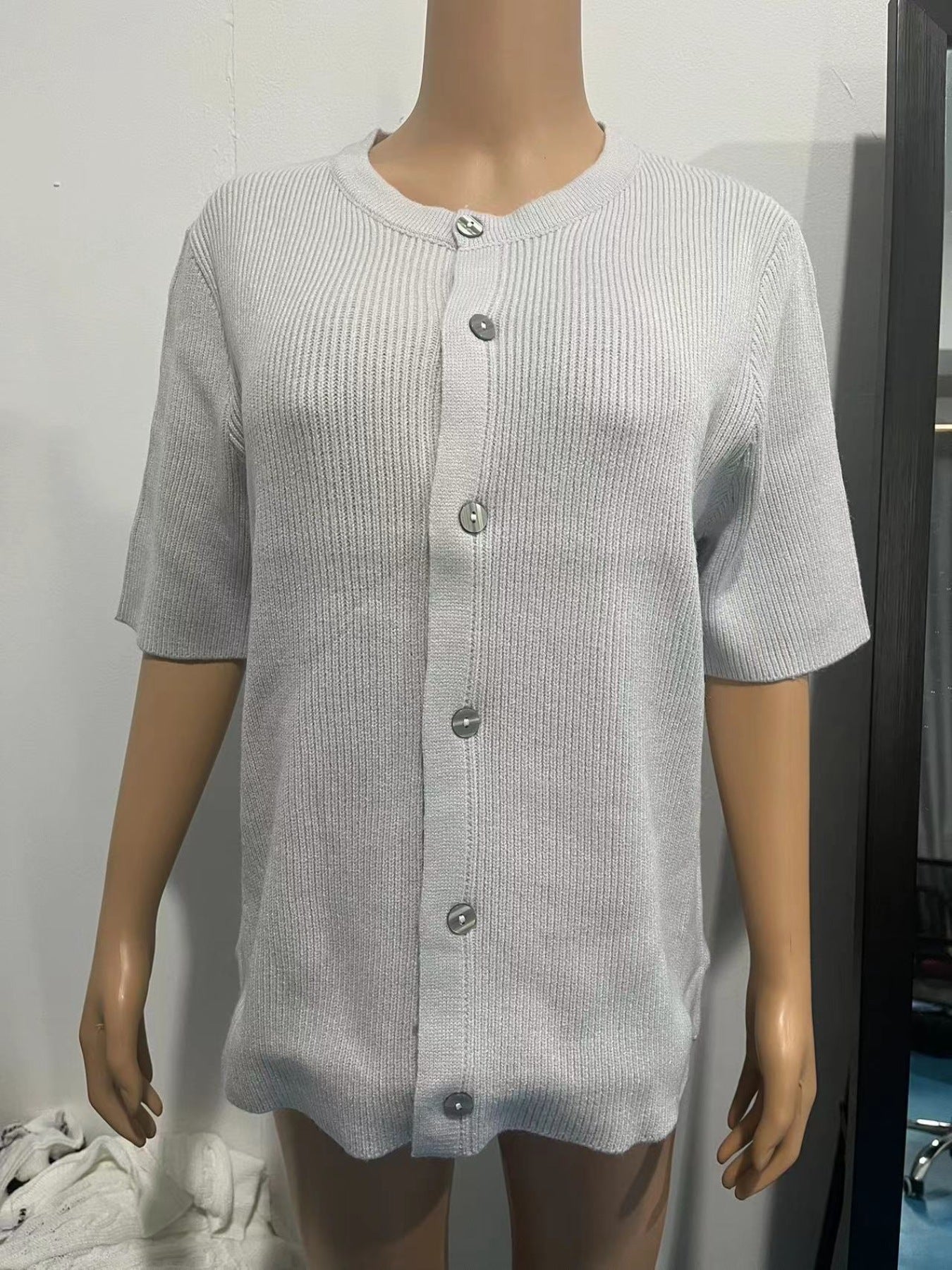 Slightly cropped gray ribbed button-down cardigan with short sleeves.