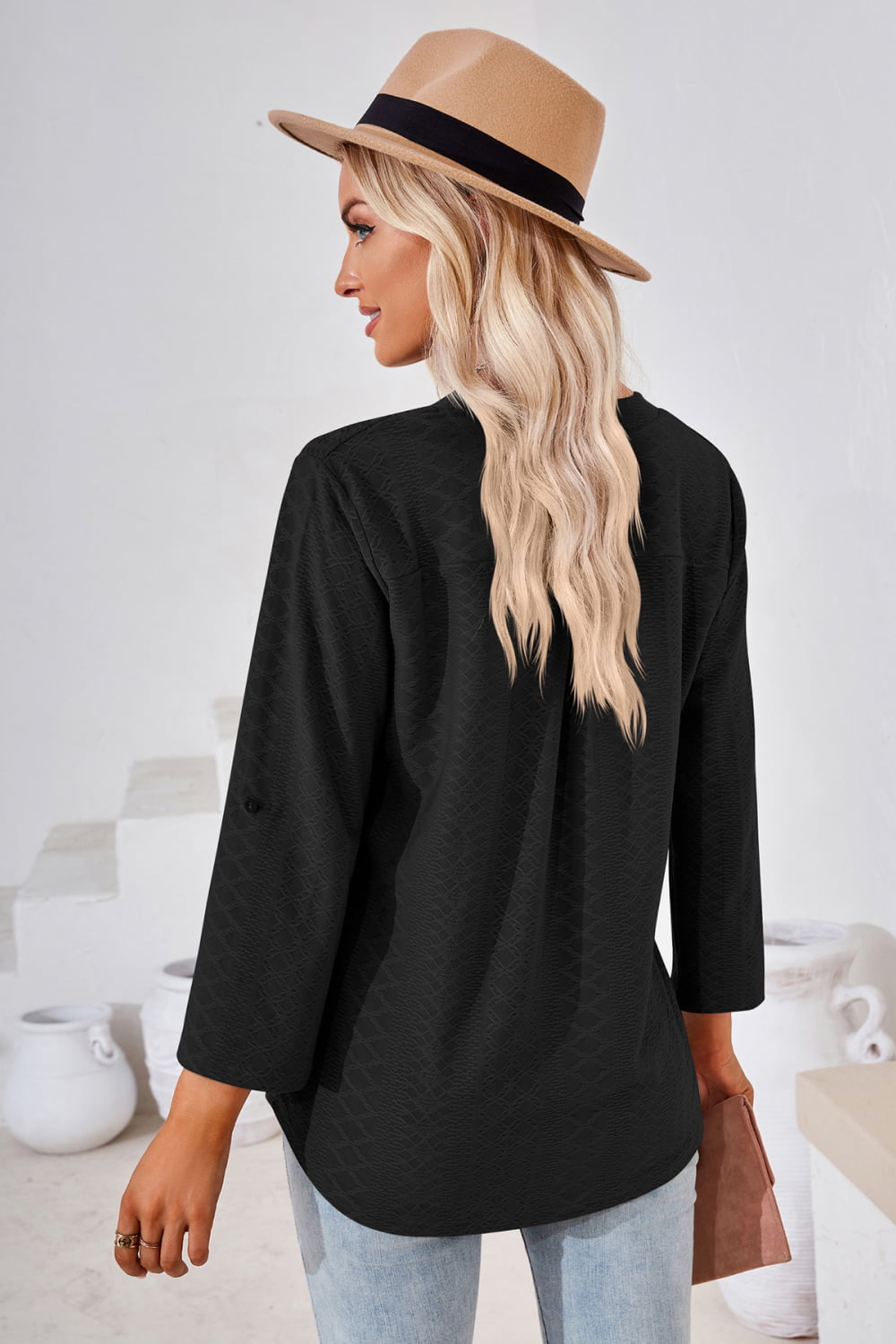 Black textured henley blouse with rolled sleeves and a curved hem.