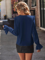 Royal blue polyester blouse with ruffled cuffs and shoulders.