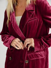 Burgundy velvet double-breasted blazer with patch pockets and button closure.