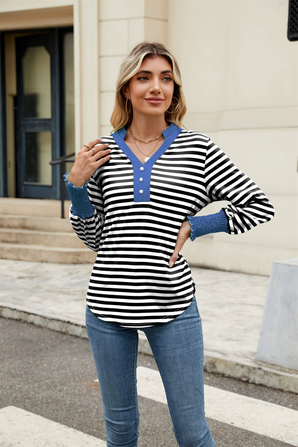 Striped long sleeve blouse with blue collar and ruffled cuffs.