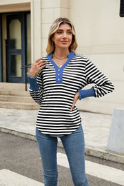 Striped long sleeve blouse with blue collar and ruffled cuffs.