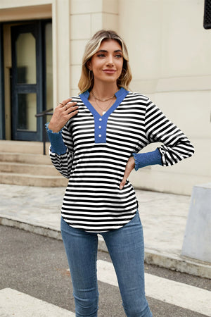 Striped long sleeve blouse with blue collar and ruffled cuffs.