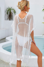 White open-knit beach cover-up with V-neck, short sleeves, and fringe hem.