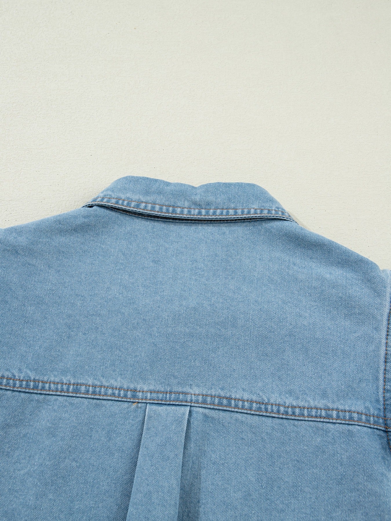 Light blue denim button-down shirt with collar and back pleat detail