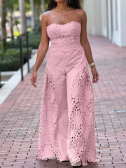 Pink strapless openwork two-piece ensemble with wide-leg pants and intricate cutouts.