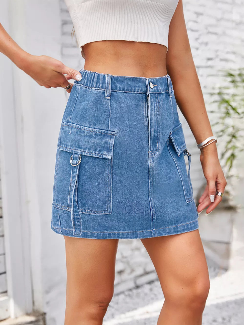Denim cargo skirt in Dusty Blue with utility pockets and a comfortable elastic waistband.