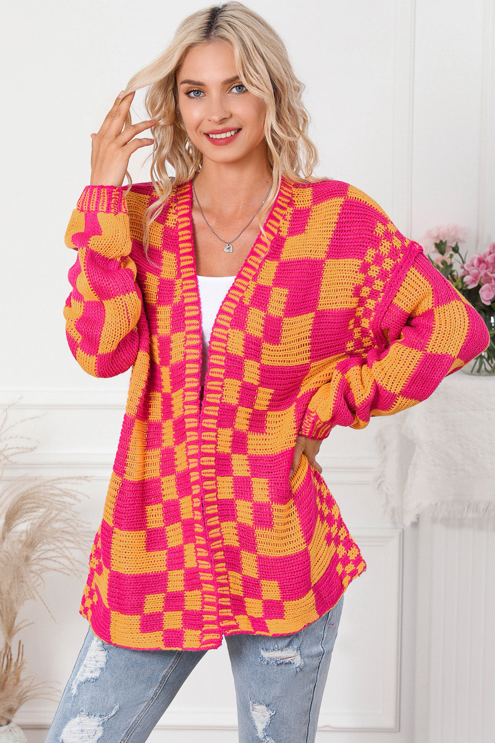 Checkerboard knit open cardigan in orange and pink acrylic with a relaxed fit.
