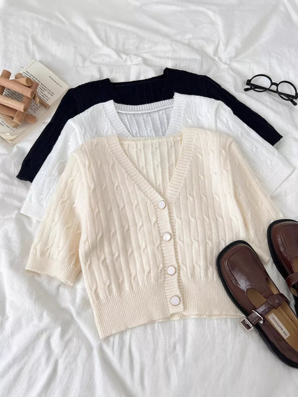 Chic cable-knit cropped cardigan in apricot with button front and V-neck.