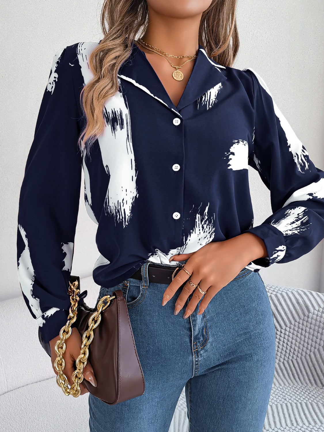 Dark blue collared blouse with white brushstroke print, button front, and long sleeves.