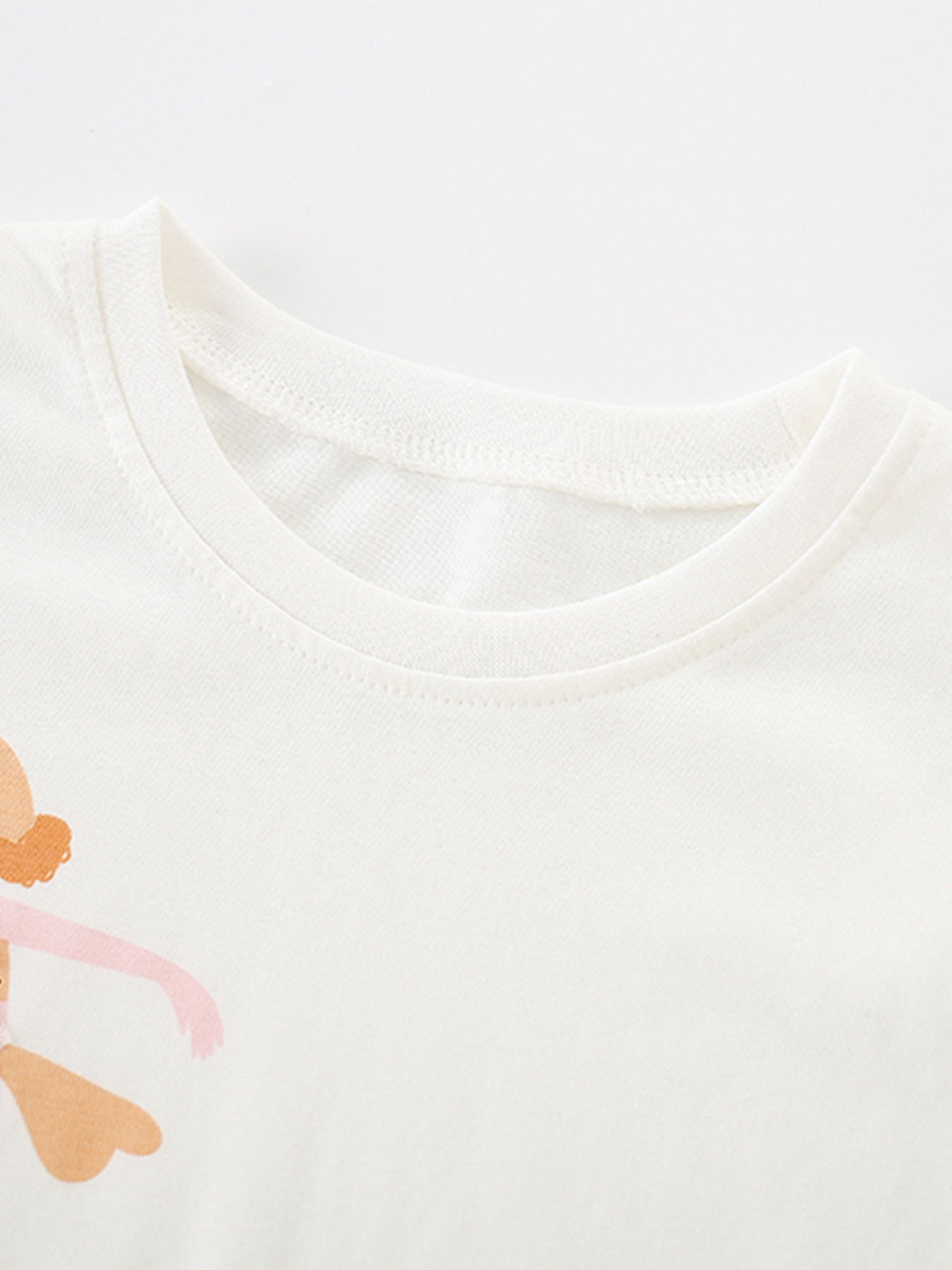 White cotton baby tee with playful graphic detail and crew neck.