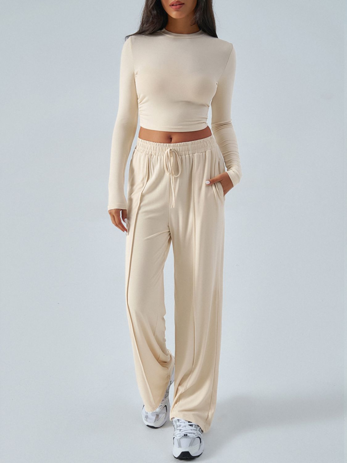 Ribbed knit crop top and wide leg pants set in tan with drawstring waist.