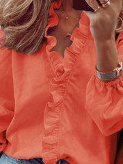 Pumpkin blouse with cascading ruffle front and balloon sleeves.