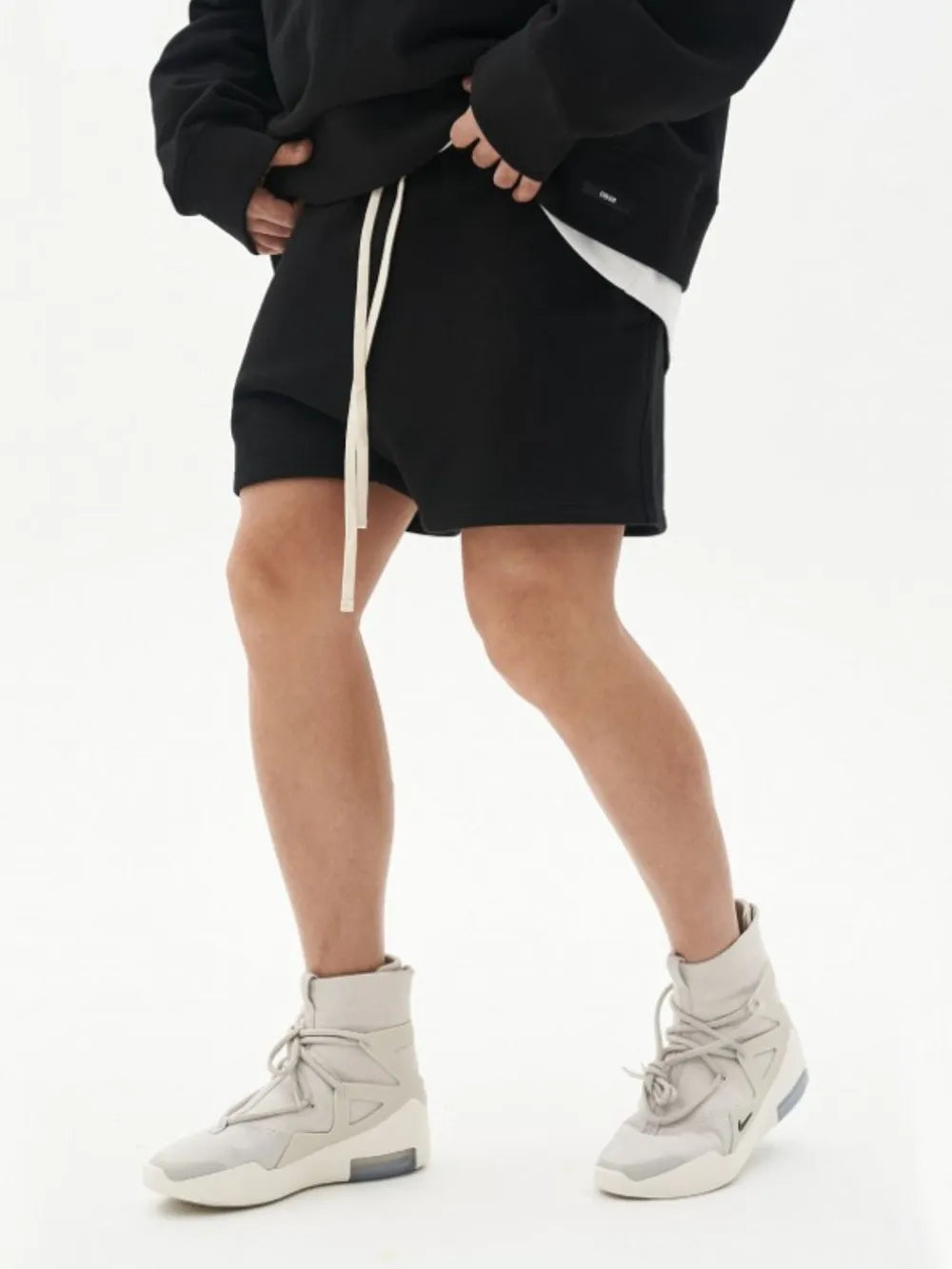 Black fleece lounge shorts with raw edges and a white drawstring.