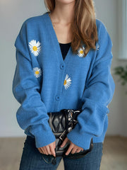 Sky blue acrylic oversized knit cardigan with embroidered daisies, button front, and V-neck.