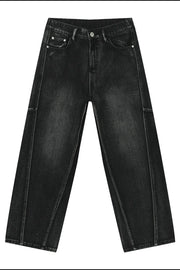 Dark wash denim trousers with exaggerated seam details and a wide leg