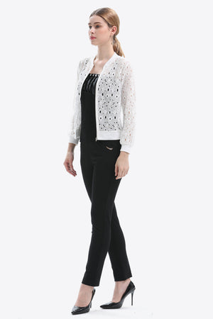 White lace-cut bomber jacket with a zip front and ribbed cuffs, styled with black pants.