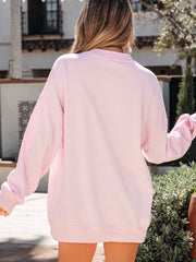 Oversized blush pink cotton crew neck sweatshirt with patchwork heart detail.