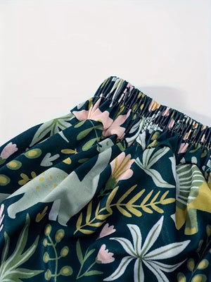 Dinosaur print elastic waist skirt in dark green with botanical accents and pink flowers.