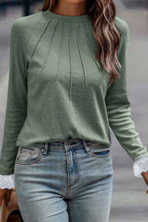 Sage green long sleeve top with pleated yoke and lace cuffs.