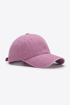 Washed cotton baseball cap in pink with adjustable strap and curved brim.
