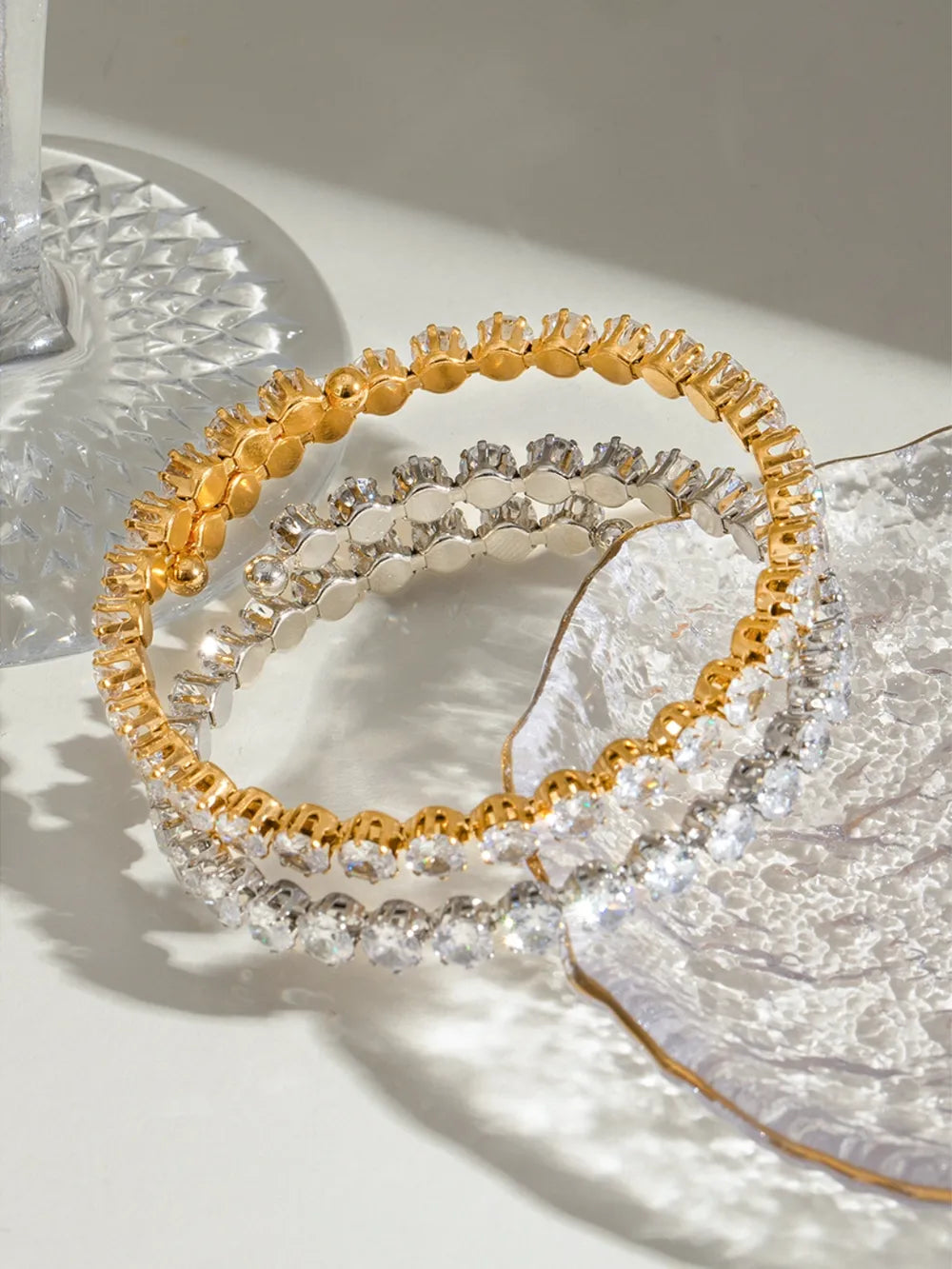 Double row pavé bangle bracelet in gold and silver with clear stones.