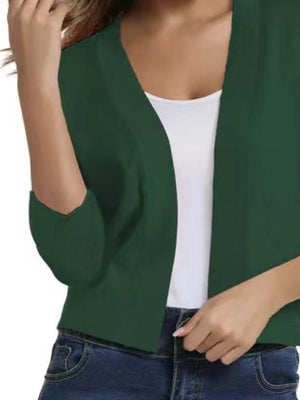 Mid Green cropped knit cardigan with elbow sleeves and open front, styled over a white tank top.