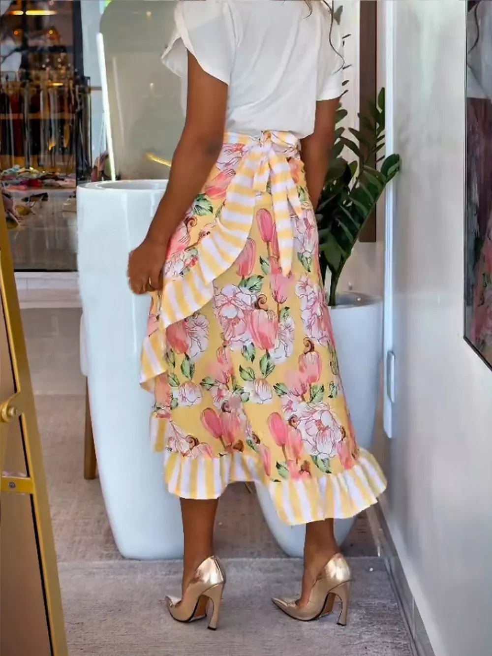 Playful floral wrap skirt with ruffle hem and striped tie waist.