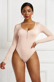 Long sleeve beige bodysuit with plunge neckline and zip front detail.