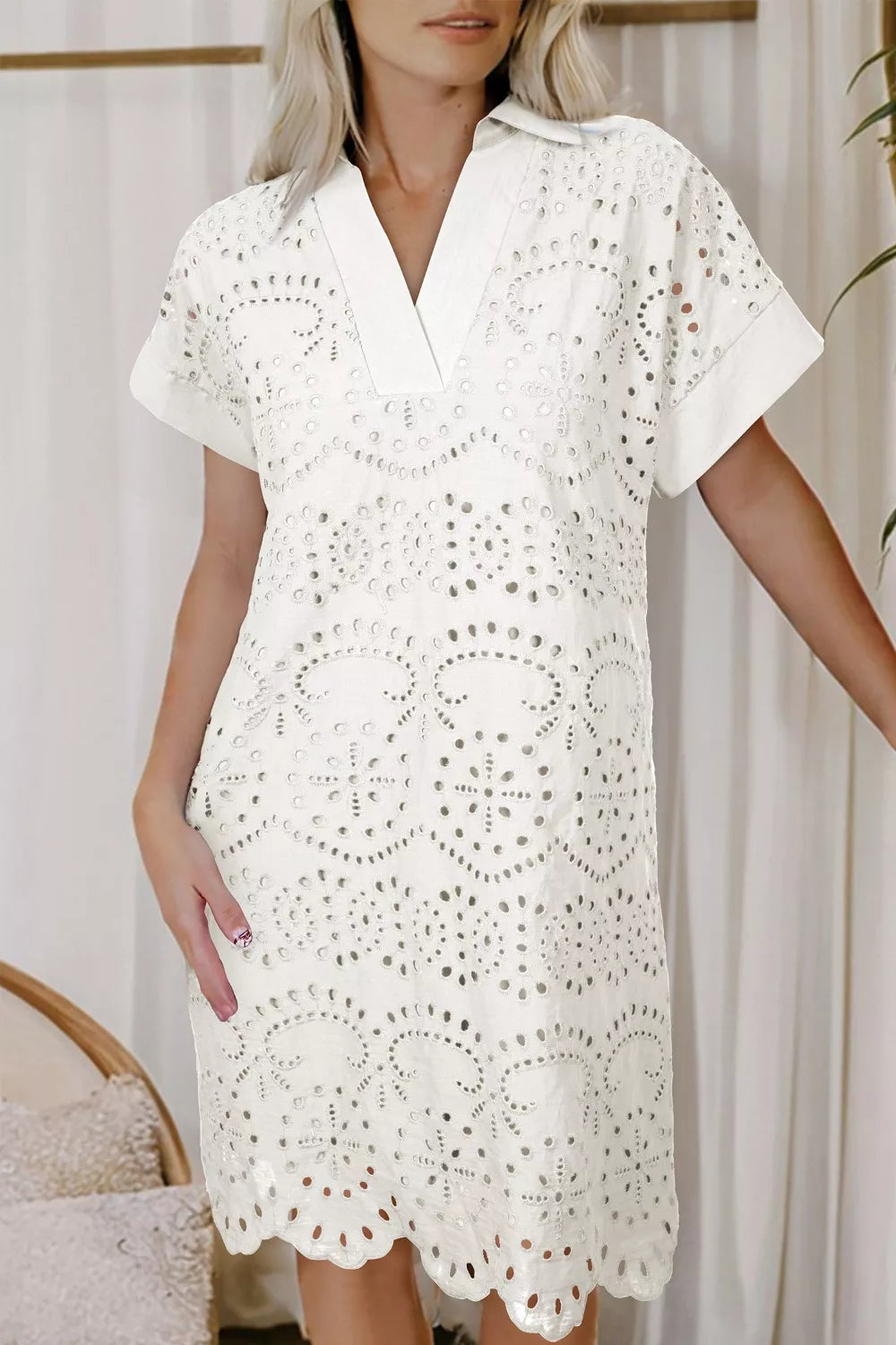 White eyelet embroidered cotton mini dress with V-neck and short sleeves.