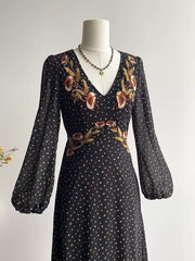 Black floral embroidered maxi dress with V-neck, long puff sleeves, and polka dot print.