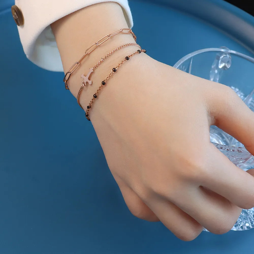 Rose gold layered chain and bead bracelet trio with a charm