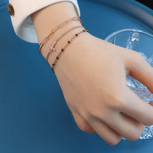 Rose gold layered chain and bead bracelet trio with a charm