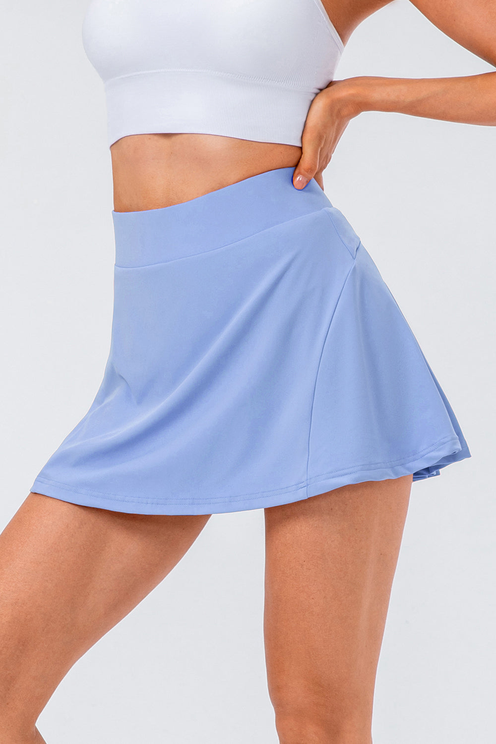 Light blue performance skort with a pleated skirt and pocket detail.