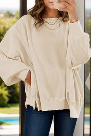 Ivory waffle knit pullover sweater with slit sleeves and a relaxed fit.