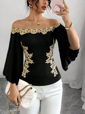 Black off-shoulder blouse with gold embroidery and bell sleeves.