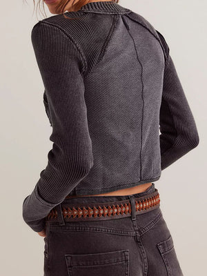 Black cable knit cropped cardigan with ribbed texture and button front detail.