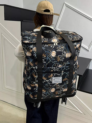 Black floral print rolling travel bag with top handles and wheels