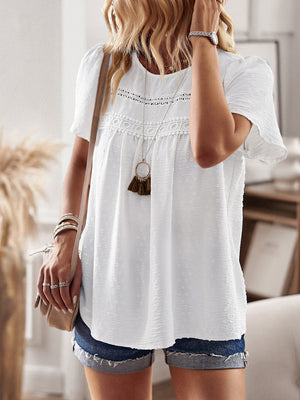 White textured puff sleeve yoke blouse with crochet trim and tassel necklace.