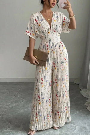 Floral pleated wide-leg jumpsuit with V-neck and short sleeves.