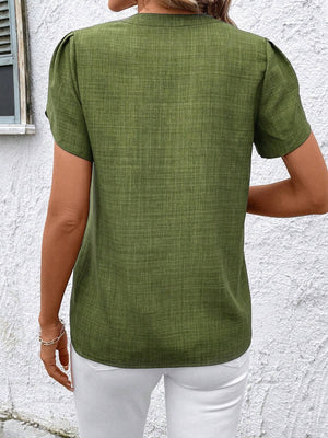 Matcha green textured blouse with short puff sleeves and a keyhole neckline.