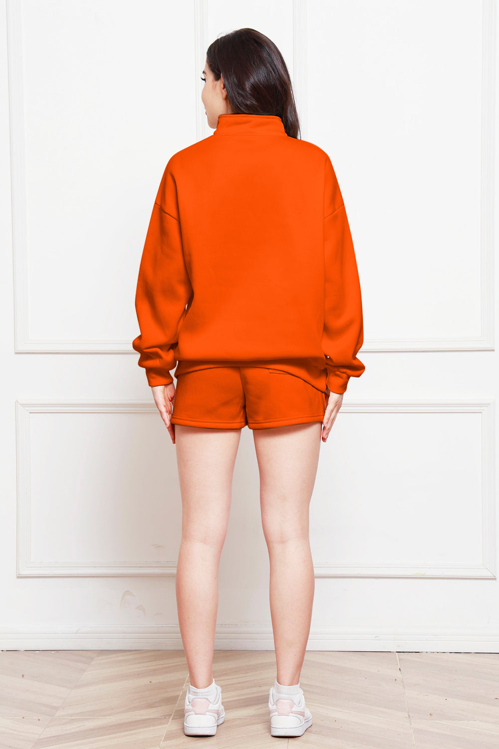 Orange quarter-zip loungewear set with shorts and a mock neck sweatshirt.