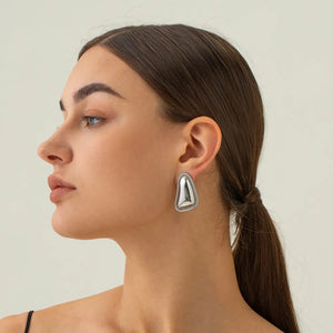 Sculpted silver vermeil earrings with textured edge detail.