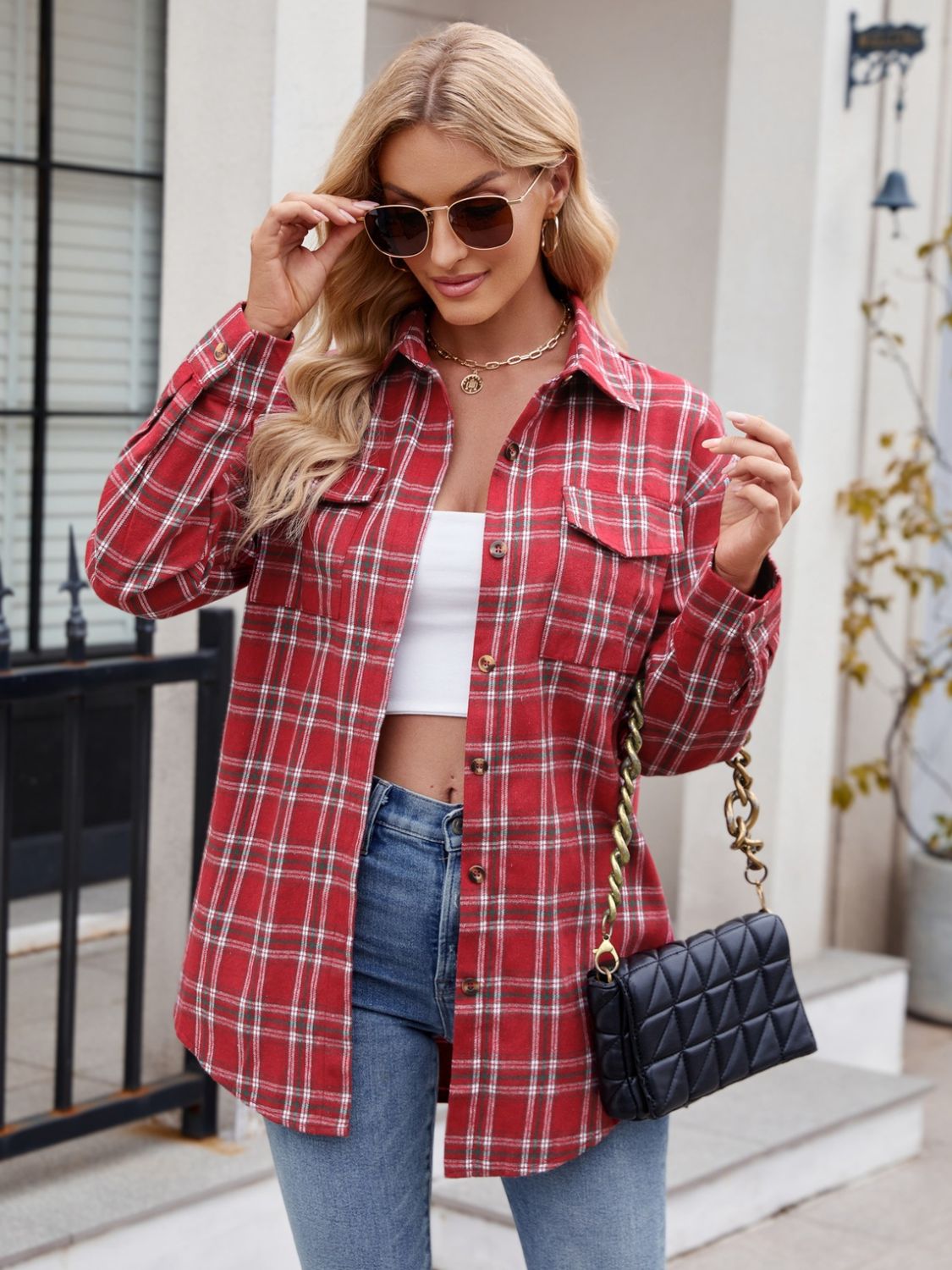 Red plaid overshirt with patch pockets and buttoned front, styled with jeans.