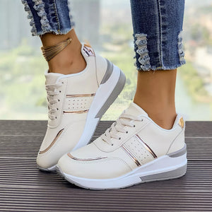 White lace-up sneakers with metallic rose gold accents and a chunky sole.