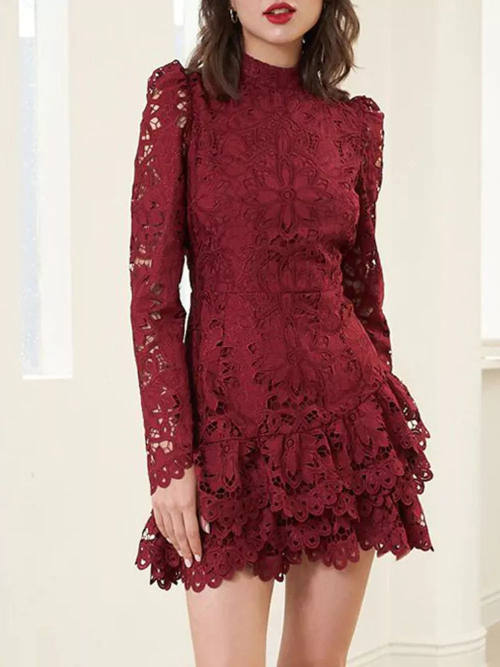Burgundy floral lace mock neck mini dress with ruffled hem and long puff sleeves.