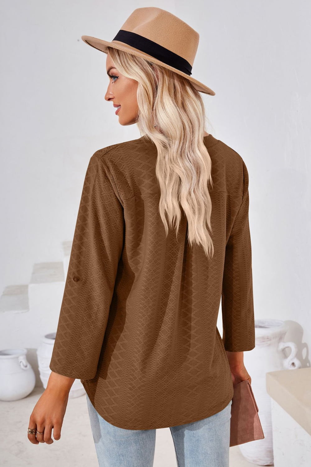 Brown textured henley blouse with rolled sleeves and a relaxed fit.